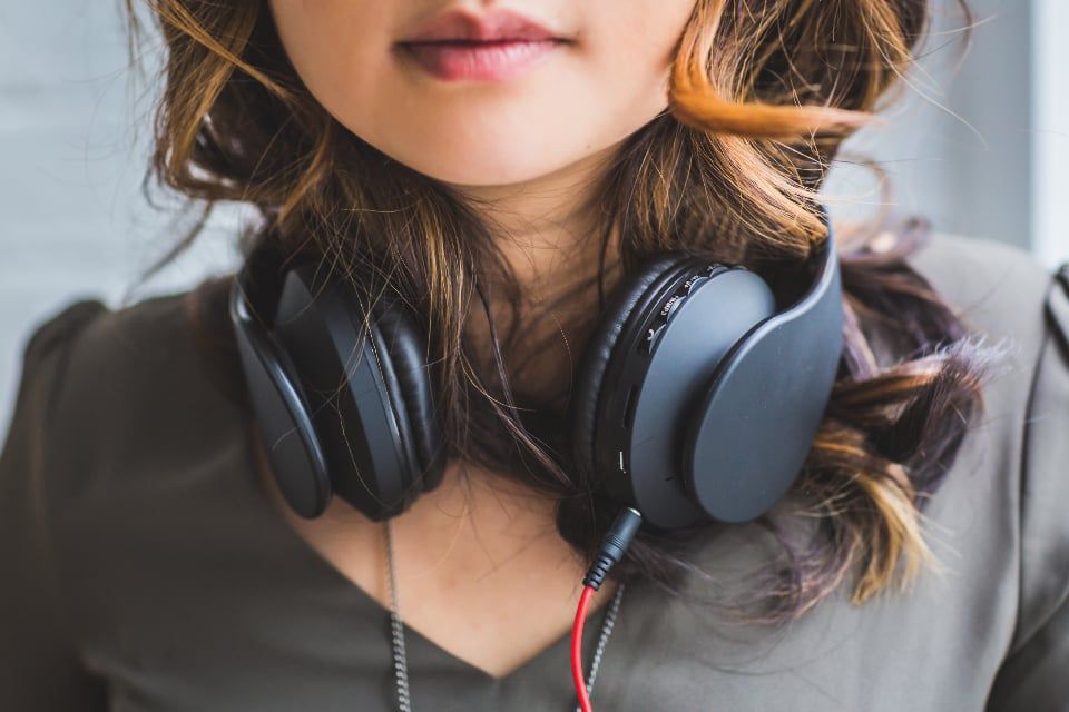 Moça com fone de ouvido no pescoço