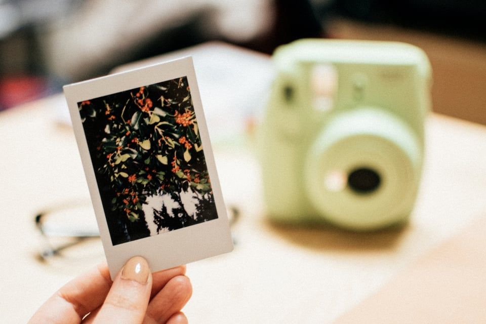 Mão segurando uma foto polaroide